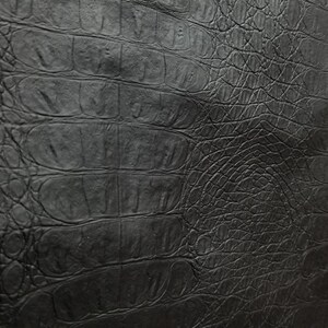 Peut inclure: Texture de cuir noir gaufr&eacute; crocodile. Le cuir pr&eacute;sente un motif gaufr&eacute; en relief qui ressemble &agrave; de la peau de crocodile.