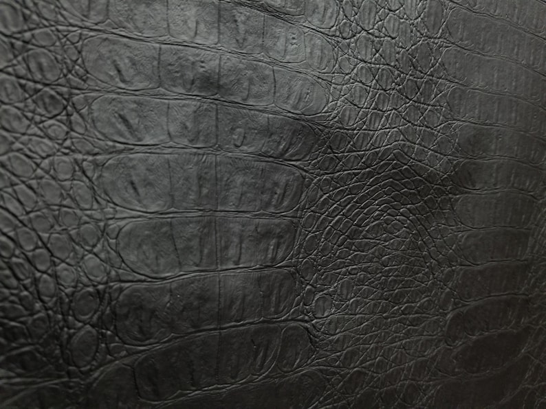 Peut inclure: Texture de cuir noir gaufr&eacute; crocodile. Le cuir pr&eacute;sente un motif gaufr&eacute; en relief qui ressemble &agrave; de la peau de crocodile.