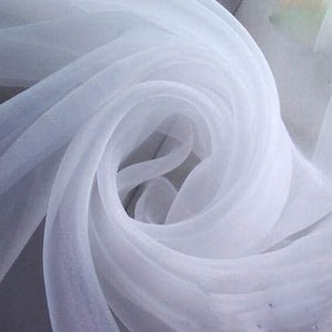 May include: White sheer fabric, soft and delicate, with a flowing, draped texture. The fabric is translucent and has a subtle sheen.