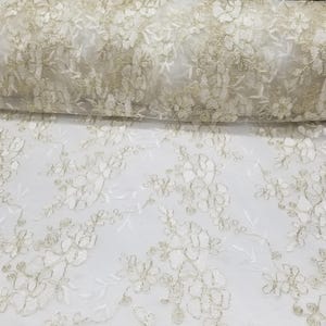 Pode incluir: Um rolo de tecido de renda marfim com um padrão floral. A renda apresenta flores e folhas bordadas detalhadas, criando uma superfície delicada e texturizada. O tecido é adequado para vestidos de noiva, vestidos ou projetos decorativos.
