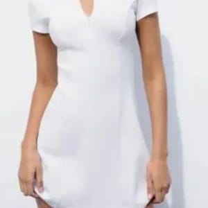 May include: A white collared dress with a zipper closure and short sleeves.