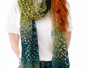 May include: A long, rectangular crochet scarf featuring an openwork, lacy stitch pattern. The yarn displays a gradient color transition, shifting from deep forest green and teal tones at the center to lighter olive and golden yellow at the ends.