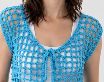 May include: A bright blue crochet vest featuring an open grid pattern, short sleeves, and two tie closures at the center front. The garment is worn over a plain white tank top and paired with light blue denim jeans, showcasing the textured knit.
