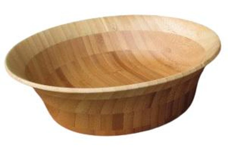 Puede incluir: Un cuenco de madera ovalado grande con un acabado marr&oacute;n claro. El cuenco tiene un borde inclinado y un interior amplio y abierto. La veta de la madera es visible en todo el cuenco, que parece estar hecho de bamb&uacute;.