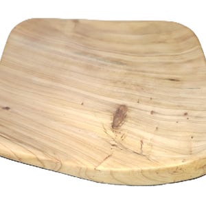 Può includere: Un tagliere in legno chiaro con una forma curva unica. La tavola presenta un motivo a venature naturali e una superficie liscia e lucida. Ideale per servire antipasti o piccoli piatti.