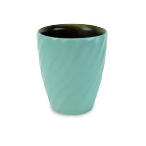 Puede incluir: Una taza de cerámica azul claro con un patrón de espiral. La taza tiene un interior marrón oscuro.