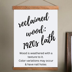 May include: A white sign with black text that reads "reclaimed wood: 1920s lath." The sign is held by wooden bars at the top and bottom, with a twine string for hanging. The text below states "Wood is weathered with a texture to it. Color variations may occur & have nail holes."