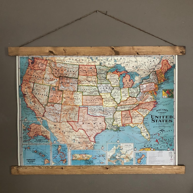 May include: A vintage map of the United States of America in a wooden frame. The map is in a blue and red colour scheme and shows the states and major cities. The map is titled "Bacon's Standard Map of the United States".