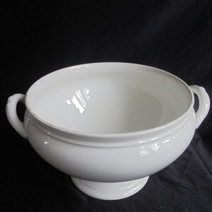 May include: White porcelain serving bowl with two handles and a pedestal base.