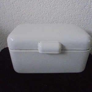 May include: White ceramic bread box with a hinged lid and a simple design.