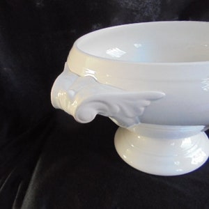 May include: White ceramic serving bowl with two ornate handles and a pedestal base.