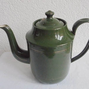 May include: A dark green enamel coffee pot with a gold trim around the middle. The pot has a rounded body and a spout on the side. The handle is attached to the top of the pot.