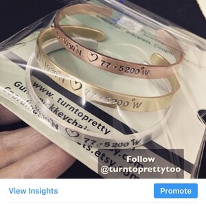 May include: Two gold, silver, and rose gold bracelets with engraved coordinates and a heart symbol. The bracelets are stacked on top of each other. The text on the bracelets reads "13.1030 N 77.5200 W", "www.turntopretty.etsy.com", and "Follow @turntoprettytoo".