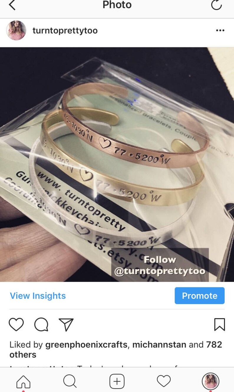 May include: Two gold, silver, and rose gold bracelets with engraved coordinates and a heart symbol. The bracelets are stacked on top of each other. The text on the bracelets reads "13.1030 N 77.5200 W", "www.turntopretty.etsy.com", and "Follow @turntoprettytoo".