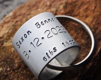 May include: Silver metal keychain with the inscription "Saxon Bennett 08.12.2023 6lbs 15oz".