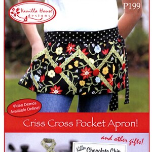 May include: A waist apron and matching kitchen accessories featuring a black fabric with a floral pattern of red, yellow, and blue flowers, accented by light green crisscross ribbon trim and red buttons. The text reads Vanilla House designs, P199, Criss Cross Pocket Apron, and Killer Chocolate Chip Cookie Mix.