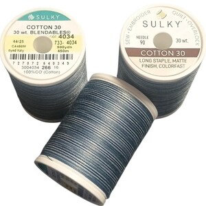 May include: Three spools of Sulky Cotton 30 Blendables thread in a variegated blue and grey color palette. Each spool features a white plastic core with printed labels indicating 30 wt, 500 yards, 450 meters, and long staple matte finish.