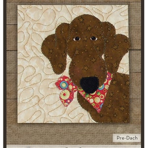 May include: A Dachshund appliqué pattern from "The Whole Country Caboodle." The image features a brown dog with star accents, wearing a red and green patterned bow tie. The text reads "Dachshund" and includes instructions for an 8-inch block.