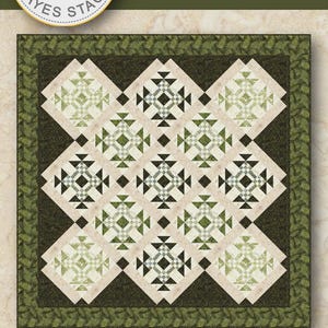 May include: A square quilt pattern titled Whispering Ferns by Needle in a Haystack, featuring a geometric design of dark green, light green, and cream fabric blocks. The quilt measures 90 inches by 90 inches and includes the Hoffman brand logo.