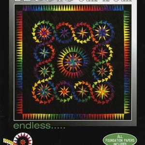 May include: A quilt pattern cover titled BE COLOURFUL endless featuring a black background with a central rainbow-colored starburst design surrounded by smaller circular star motifs and a triangular border. Text includes Quilt Designed by Jacqueline de Jonge.