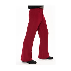 May include: Red flared pants with a high waist. The pants have a classic bell-bottom style, with a fitted upper portion that flares out from the knee. The pants are made of a solid red fabric and are paired with black shoes.