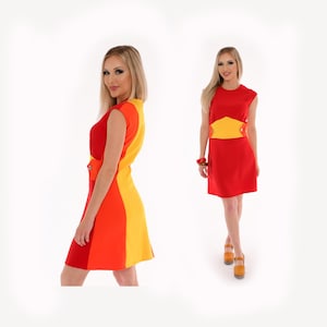 Puede incluir: Un vestido sin mangas con un diseño geométrico en rojo, naranja y amarillo. El vestido tiene un corpiño ajustado y una falda acampanada.
