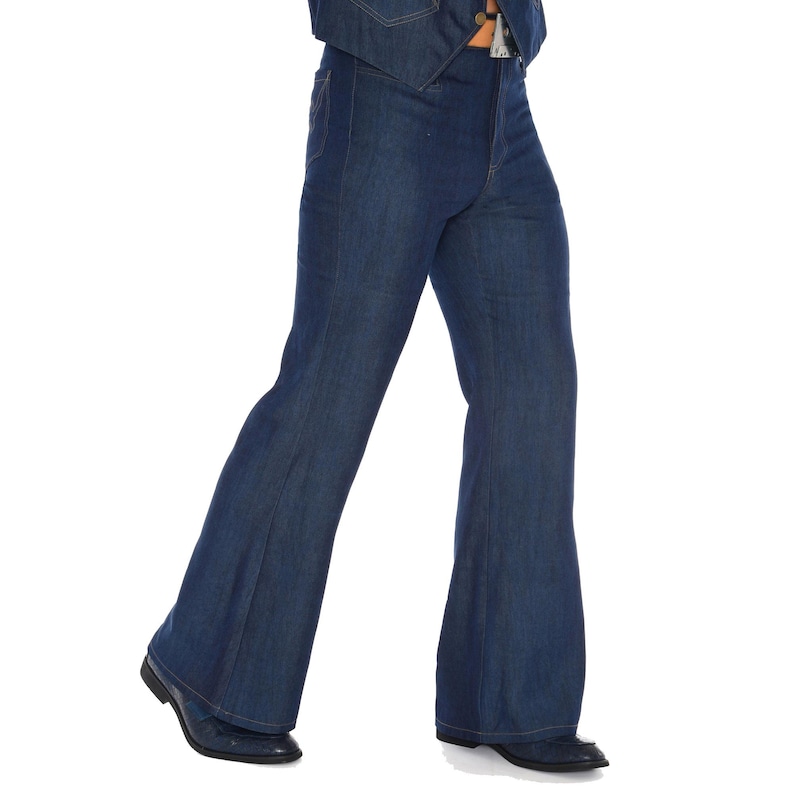 May include: Dark blue denim bell-bottom pants. The pants have a high waist and a wide flare from the knee down. The pants are paired with black dress shoes. The denim jacket is visible at the top of the image.