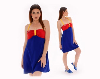 May include: A blue and red halter dress with a yellow trim and a red flower embellishment. The dress has a fitted bodice and a flowing skirt.
