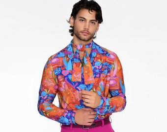 Puede incluir: Una camisa de manga larga con estampado floral colorido en tonos naranja, azul y rosa. La camisa tiene cuello y corbata.
