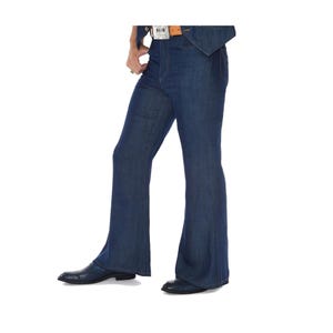 May include: Dark blue denim bell-bottom jeans. The jeans have a high waist and a flared leg from the knee down. The model is wearing a brown belt with a silver buckle and black shoes.