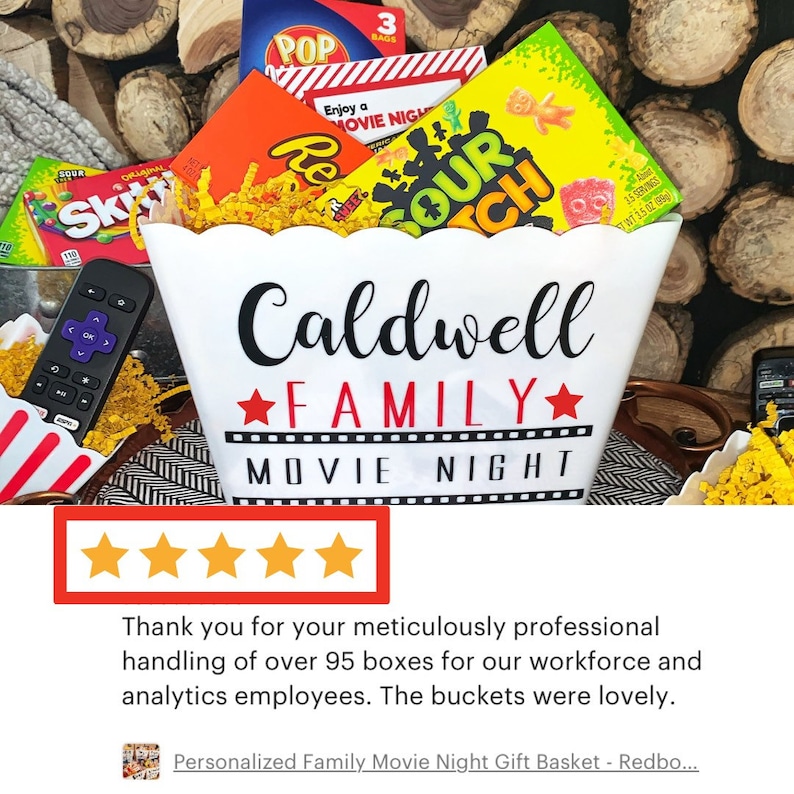 Puede incluir: Un cubo de palomitas blanco con el texto "Caldwell Family Movie Night" impreso en &eacute;l. El cubo est&aacute; lleno de varios bocadillos, incluyendo dulces, palomitas de ma&iacute;z y un control remoto.