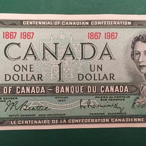May include: A 1967 Canadian one-dollar banknote, celebrating the Centennial of Canadian Confederation. The bill has text in English and French, a portrait of a woman, and the words "ONE DOLLAR".