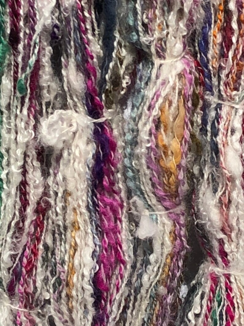 Lock spun white Teeswater wool with multi colored longwool locks added. Hand spun wool art yarn