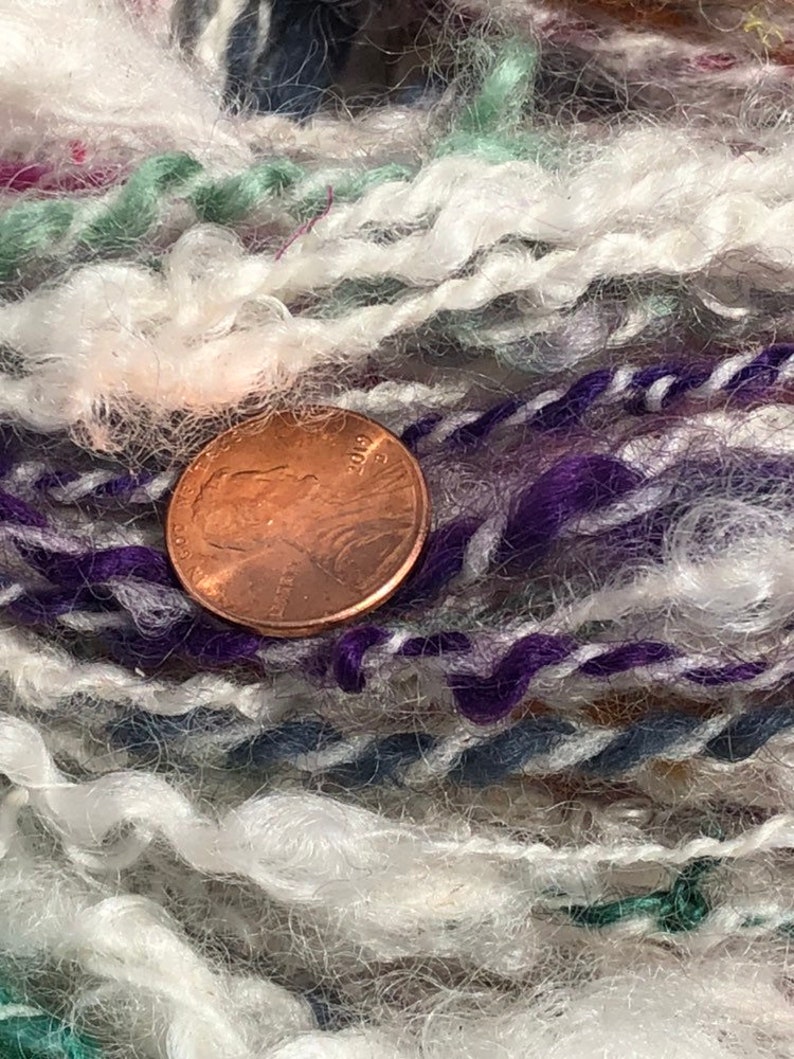 Lock spun white Teeswater wool with multi colored longwool locks added. Hand spun wool art yarn