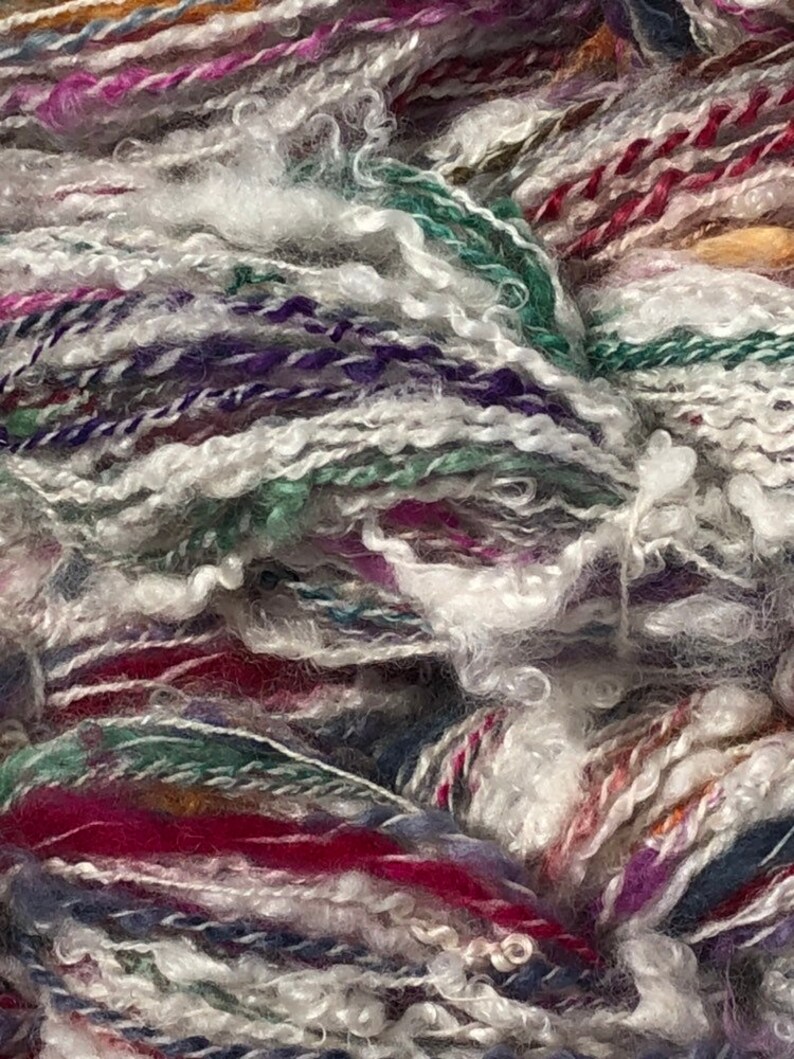 Lock spun white Teeswater wool with multi colored longwool locks added. Hand spun wool art yarn