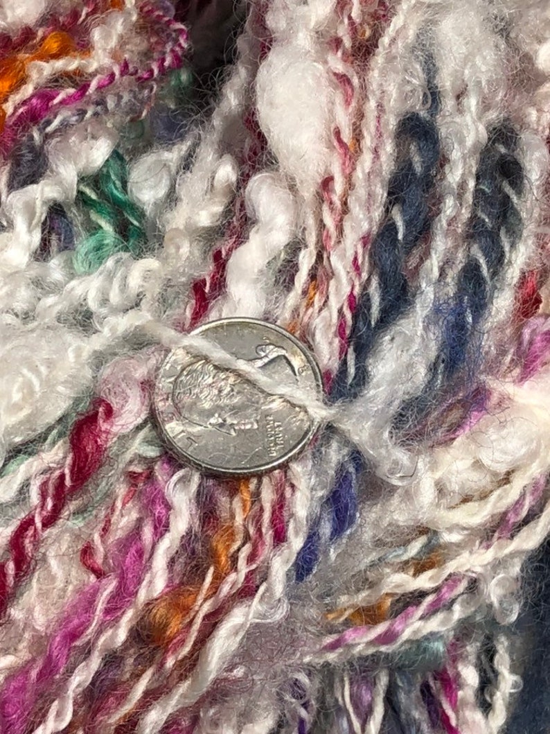 Lock spun white Teeswater wool with multi colored longwool locks added. Hand spun wool art yarn