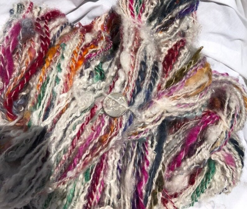 Lock spun white Teeswater wool with multi colored longwool locks added. Hand spun wool art yarn