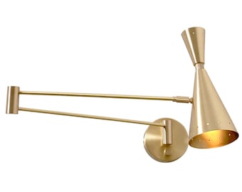 May include: A gold-toned wall sconce with a long, adjustable arm and a cone-shaped shade. The shade has a pattern of small holes.