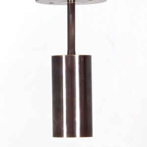 May include: A brushed bronze pendant light fixture with a cylindrical shade and a circular canopy.