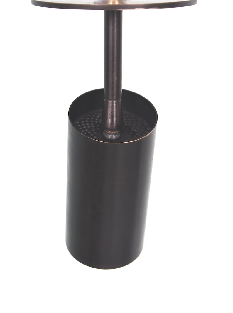 May include: A black metal toilet brush holder with a round top and a cylindrical base.