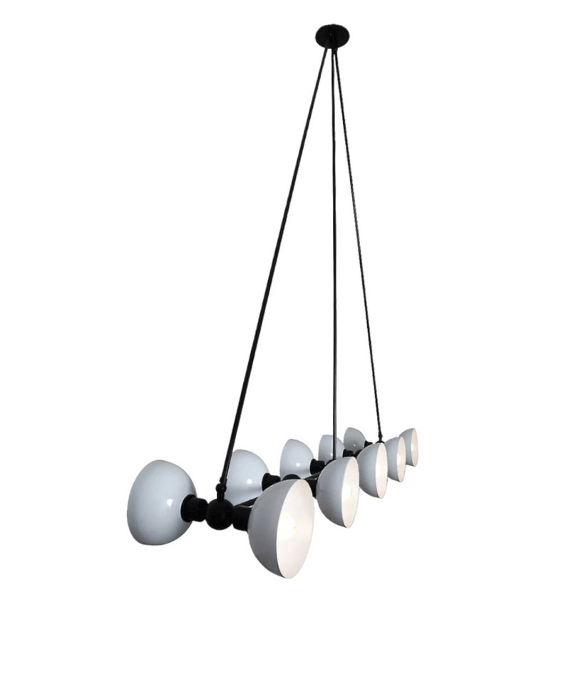May include: A black metal chandelier with eight white globe-shaped light shades. The chandelier has a long, thin design and hangs from a single point.