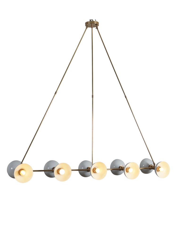 May include: A brass and white chandelier with six lights. The chandelier has a triangular frame and the lights are arranged in a line.