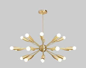 May include: A gold-toned chandelier with multiple arms extending outwards, each arm ending in a light bulb. The chandelier has a modern, geometric design.