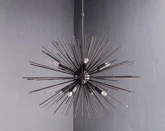 May include: A modern, black metal chandelier with a starburst design. The chandelier has multiple arms that extend outward from a central point, creating a dramatic and eye-catching effect. The chandelier is suspended from the ceiling by a single chain.