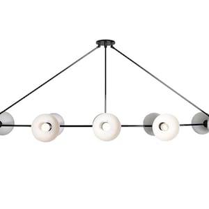 May include: A black metal chandelier with six white glass globe lights. The lights are arranged in a linear pattern with three lights on each side of a central support.