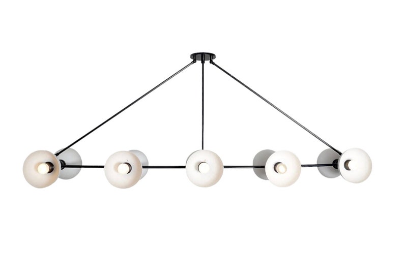 May include: A black metal chandelier with six white glass globe lights. The lights are arranged in a linear pattern with three lights on each side of a central support.