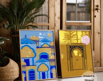 May include: Two framed art prints with gold frames. One features a blue and gold illustration of buildings with domes. The other has a yellow background with a black archway design and a pink circle. The text "Printed & Shipped" is visible.