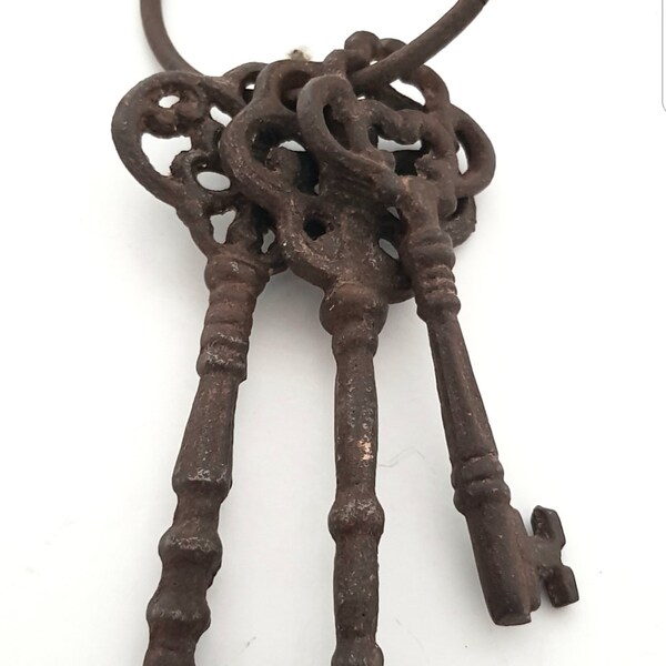 A set of three large Victorian skeleton keys on an iron ring, antique keys, ornate key.