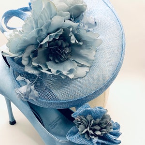 May include: A light blue satin pump with a matching light blue flower and a light blue hat with a large light blue flower.