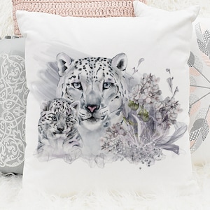 Puede incluir: Una almohada blanca con una ilustración de acuarela de una madre y un bebé leopardo de las nieves con delicadas flores moradas.